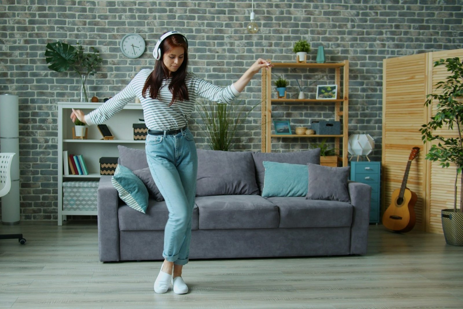 Person steht von einem Sofa auf glattem Boden auf